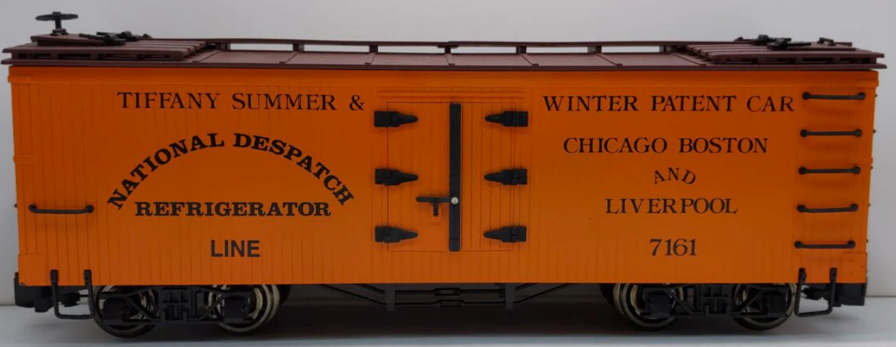 An orange Bachmann National Despatch refrigerator reefer model train car with metal wheels and text detailing.