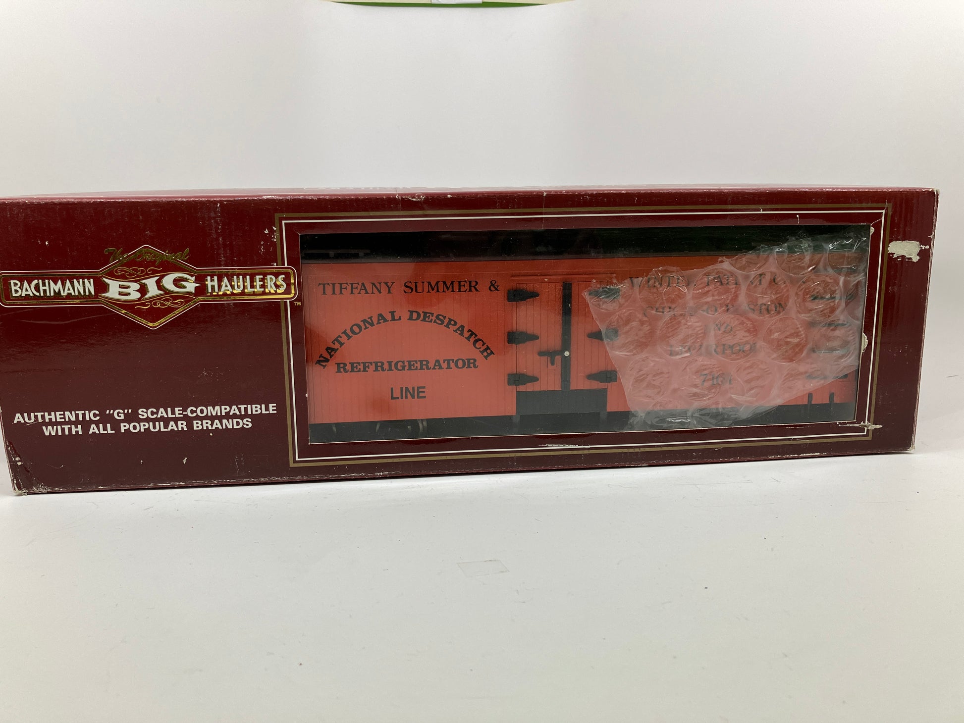 An orange Bachmann National Despatch refrigerator reefer model train car with metal wheels and text detailing.