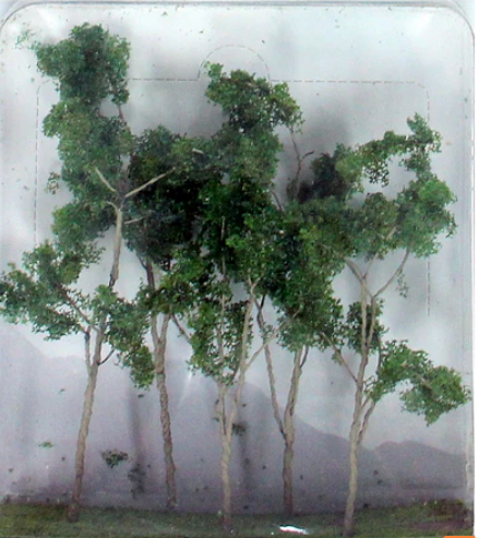 A clear plastic package containing several green model trees and shrubs designed for use with O scale model trains.