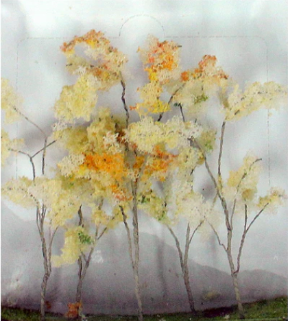 A set of beige and green artificial wooden trees designed for O-scale model railroads.