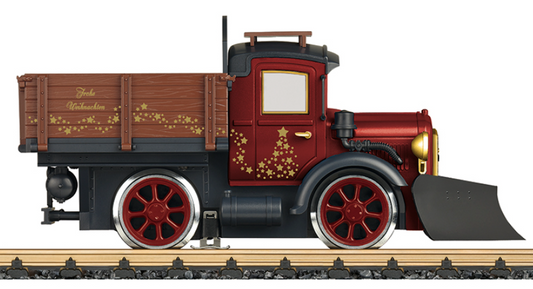 A model of a red and black rail truck with Christmas decorations, featuring driven wheels and a Bühler motor.
