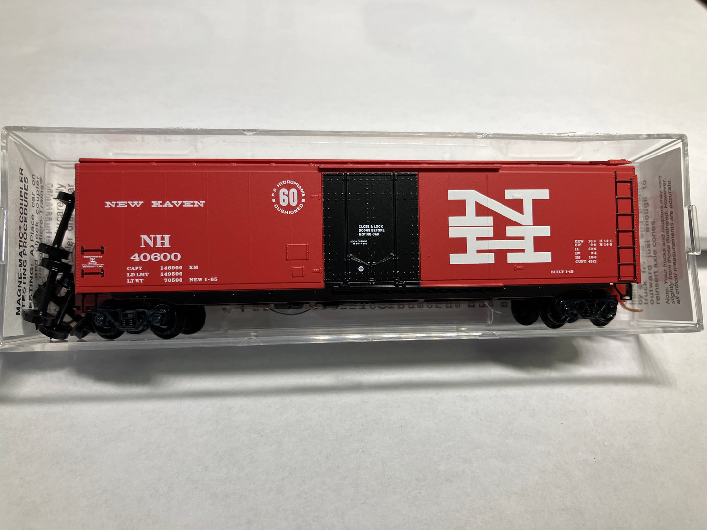 A red Micro Trains New Haven 50' standard box car with a plug door, packaged in a clear plastic box.