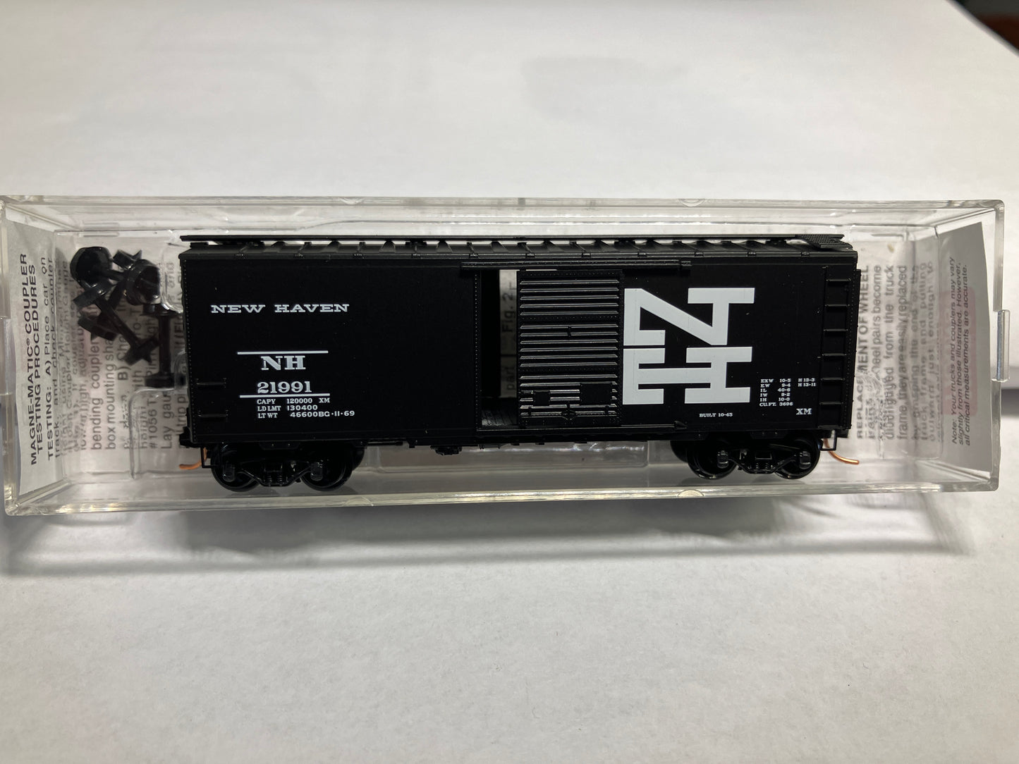 A black Micro Trains 20686 New Haven 40' standard box car model with a single door, displayed in clear packaging.