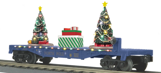 A blue toy train car with lighted Christmas trees on its side, designed to fit onto a track.