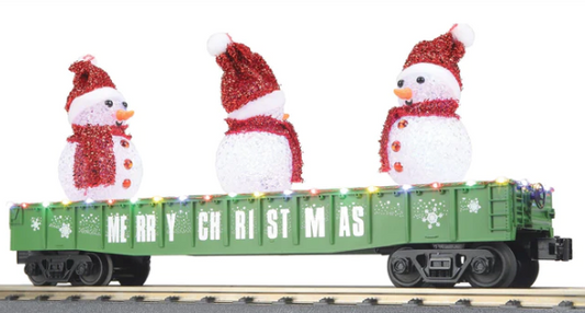 A green toy train gondola car with LED lights and a lighted snowman figure in red and white colors, designed for use in a Christmas-themed train set.