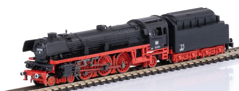 Model steam locomotive on a track with a clear background