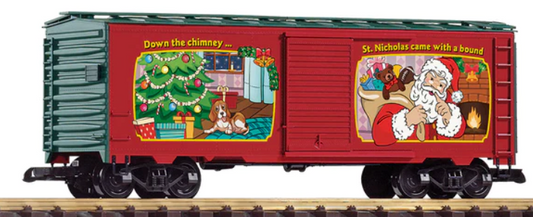 A red Christmas-themed model train car with festive decorations, including a Christmas tree and holiday-related imagery.