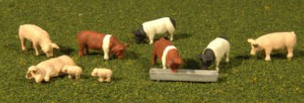 A set of Bachmann HO scale model pigs in various colors, designed for model train setups.