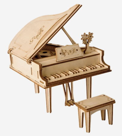 Wooden model of a grand piano with a stool on a white background