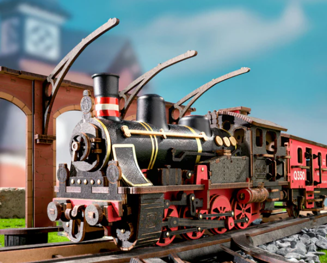 Model steam locomotive on tracks with a blurred background