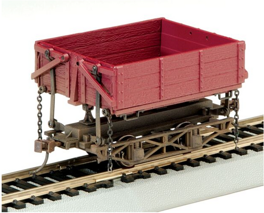 Bachmann wood side-dump car toy train car with a red body and brown dump bed, diecast metal frame, and metal wheels and axles.