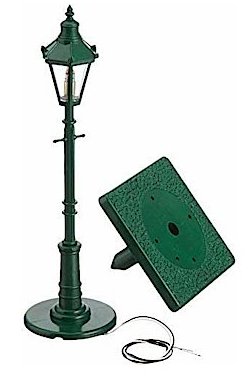 A green street light with a lamp pole and a base, designed for model railroads.