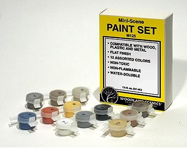 A set of various colored paint containers displayed in front of a box labeled 'Mini-Scene PAINT SET' from Woodland Scenics.