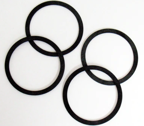 Four black rubber traction tires for model trains.