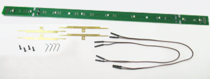 Green interior light for a model train with visible wiring and connectors.