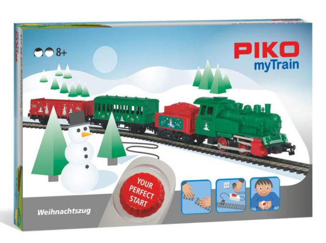 PIKO MyTrain Starter Set Christmas edition with a steam locomotive, tender, two freight wagons, track pieces, a throttle, and a power adapter, all packaged in a festive-themed box.