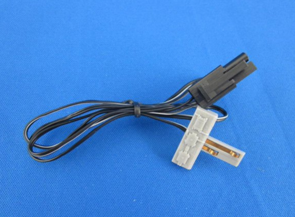 A black connector cable for Z scale model train track systems, with a white plug and black wiring visible against a blue background.