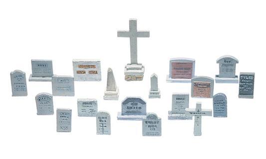 A collection of various tombstones and related scenic details designed for model train layouts, featuring different shapes and designs, including rectangular, square, and rounded tombstones, as well as obelisks, crosses, and spires.