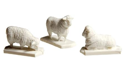 A set of model sheep, with twelve white figures and one black figure, positioned on a plain surface.