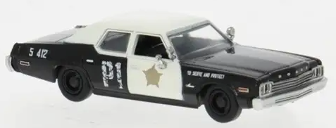 A diecast model of a black and white vintage sheriff's department car with a gold star emblem and 'DE TOILETTE AND PROSTATE' text on the side, shown against a plain white background.