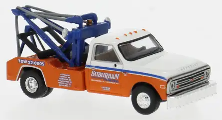 A diecast model of a 1971 Ford Crown Victoria tow truck, featuring an orange and white body with blue towing equipment on the back, shown on a white background.