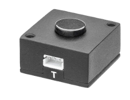 A small black rectangular electronic component with a circular top button and a white connector labeled 'T', shown on a plain white background.