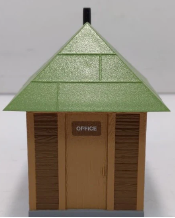 Model of a small office building with a green roof on a white background