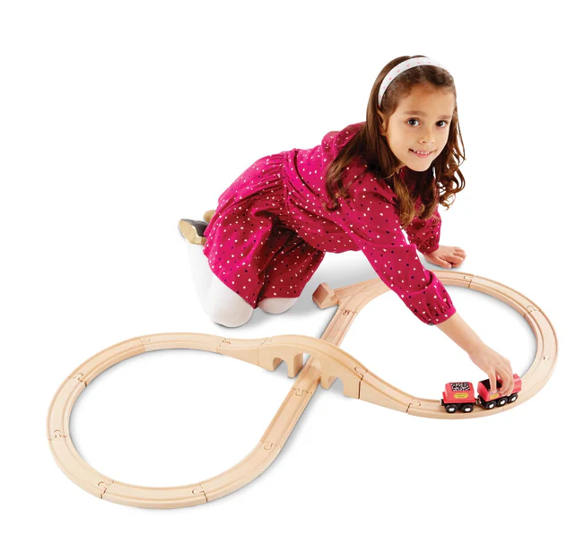 Child playing with a wooden train set on a white background