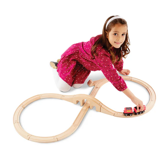Child playing with a wooden train set on a white background