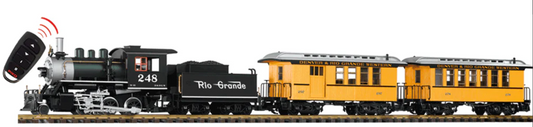 Model train set with steam locomotive and passenger cars on a track, featuring Rio Grande branding.