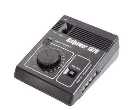A black MRC AA370 RAILPOWER 1370 DC POWER PACK designed for model trains, featuring a dial and buttons on top for control.