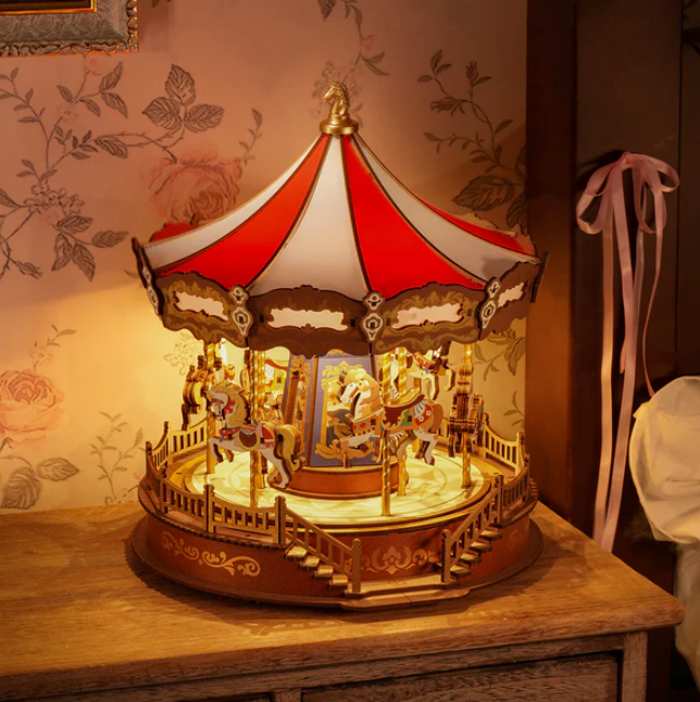 Decorative carousel lamp on a wooden surface with floral wallpaper in the background