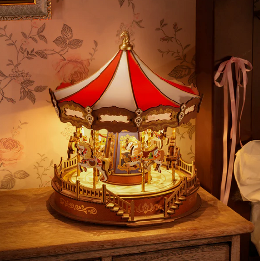 Decorative carousel lamp on a wooden surface with floral wallpaper in the background