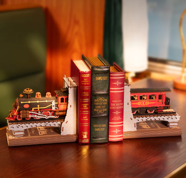 Bookends shaped like train engines on a wooden surface with a blurred background
