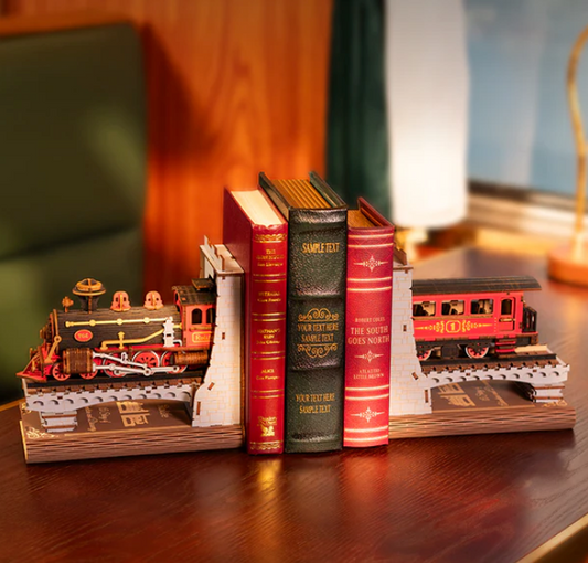 Bookends shaped like train engines on a wooden surface with a blurred background