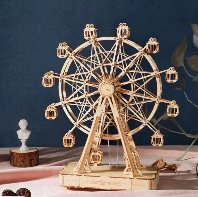 Wooden model of a Ferris wheel on a dark blue background