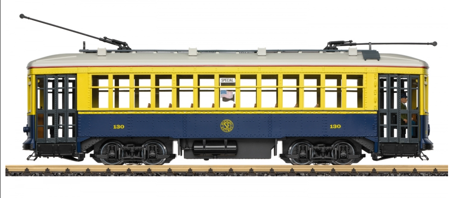 A model of a yellow and blue San Francisco streetcar with a number 130 on the side, displayed on tracks