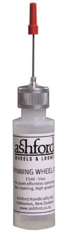 A bottle of Ashford spinning wheel oil with a red applicator needle.