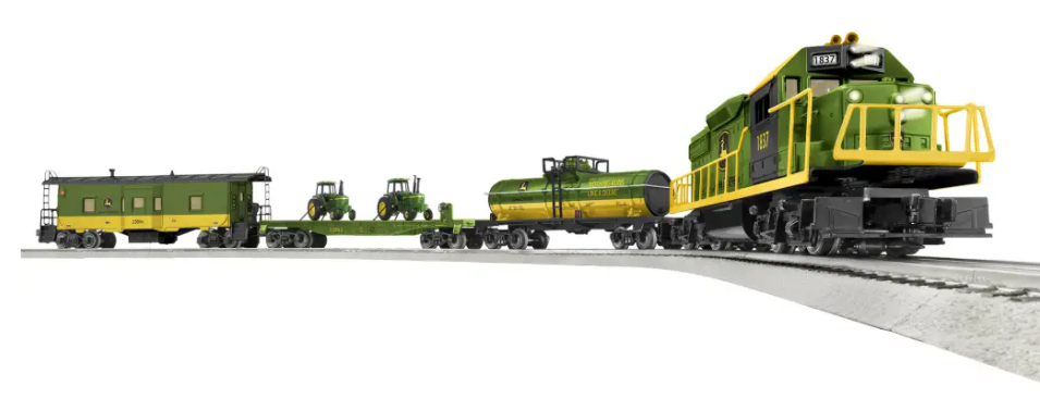 A model of a John Deere GP38 diesel locomotive with several rail cars including a tank car, flatcar with tractors, and a caboose. The train is green and yellow with a metal frame and die-cast metal trucks.