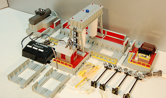 A detailed model of a Steam Clean and Wheel Grind Shop for toy trains, featuring various mechanical parts and a central control unit.