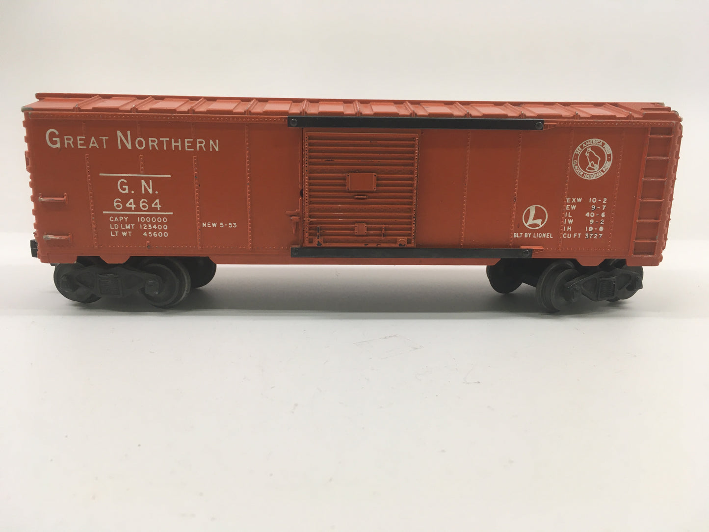 Lionel Great Northern Boxcar 53-54 toy train car with orange body and black trucks, showing typical wear.