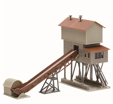 A model of a ballast transportation system with a conveyor belt, built-up structure, and a railroad spur, primarily in gray and brown tones.