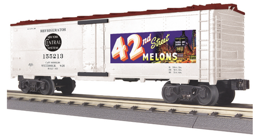 An O scale model of a modern reefer car with a colorful '42nd Street Melons' paint scheme, metal wheels, and axles, on tracks.
