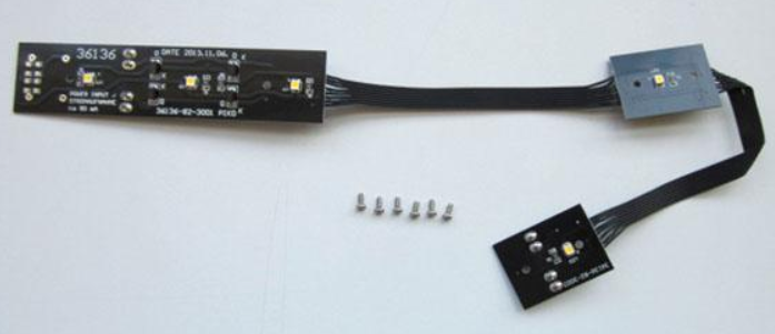 PIKO interior light for a Drovers Caboose, consisting of a black light bar and several small metal components.