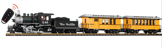 A model of a D&RGW passenger train set with analog sound and smoke, including a black and yellow locomotive, a tender, and two passenger cars on tracks.