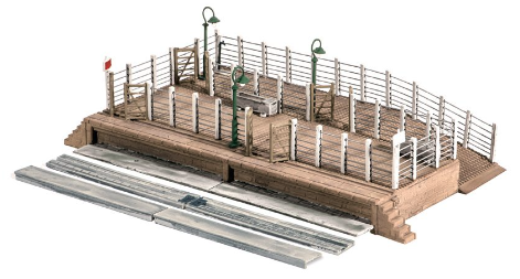 Model of a cattle dock with multiple pens and a train track, complete with a small model train and accessories.