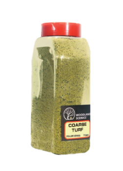 A plastic jar labeled 'Woodland Scenics Coarse Turf' containing yellow grass shaker for model making.