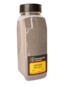 A container of Woodland Scenics grey medium ballast shaker for model trains.