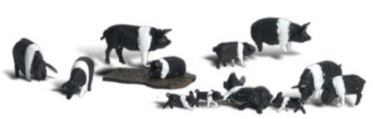 A collection of pig and piglet figures in various poses and a pig wallowing in a mud hole, intended for use in model train setups.