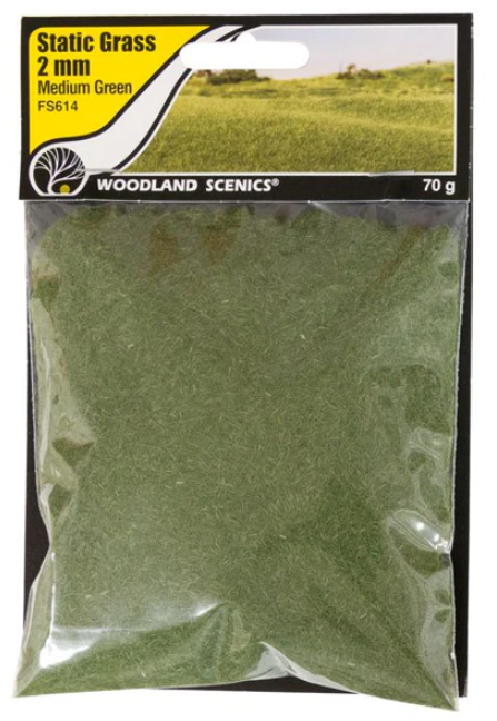A pack of Woodland Scenics FS614 Static Grass in medium green color, designed for model train use.